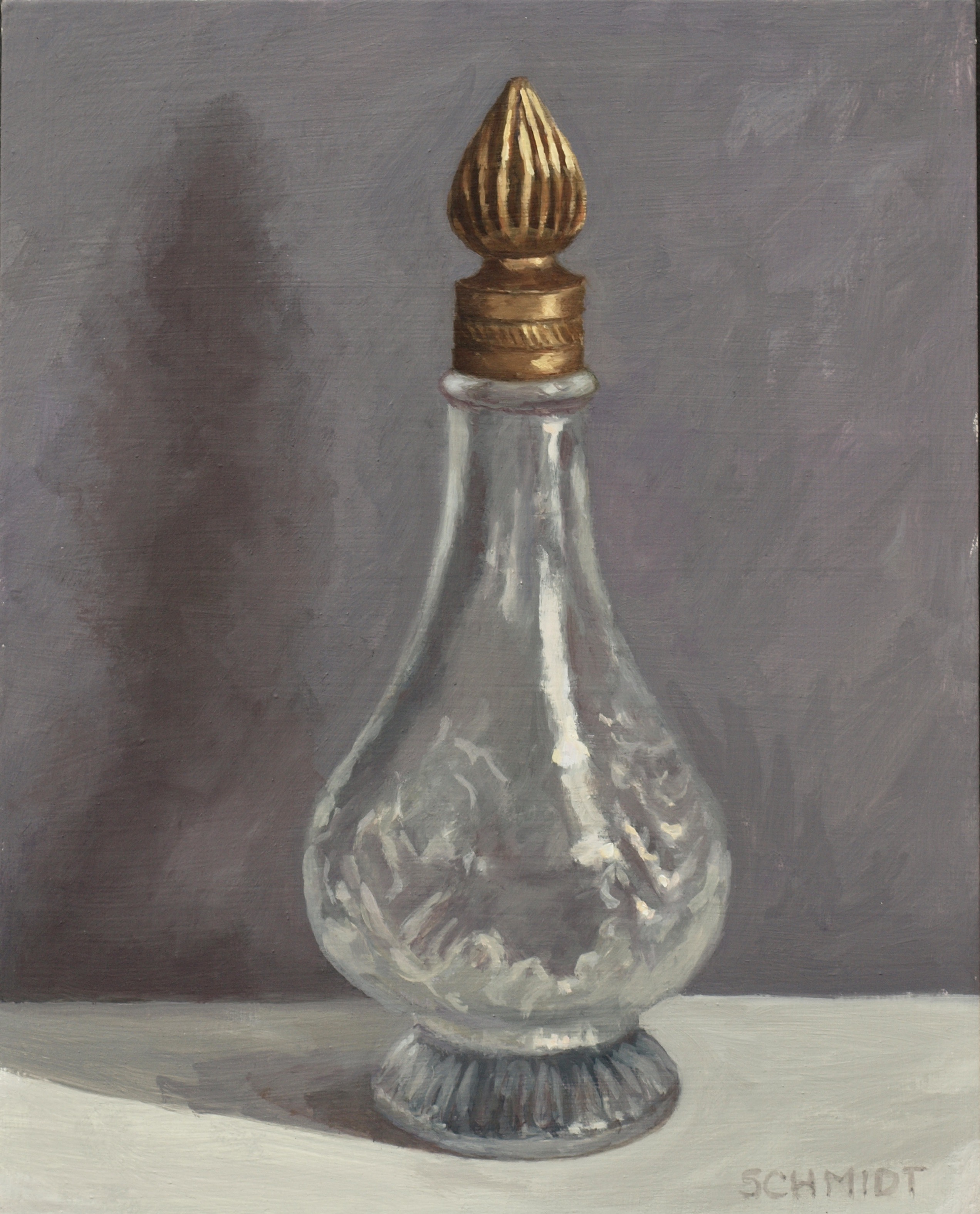 clear perfume bottle with brass top and shadows